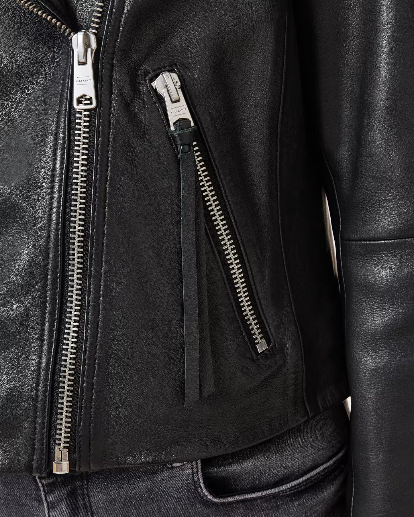 Close-up of a black leather jacket with zippers