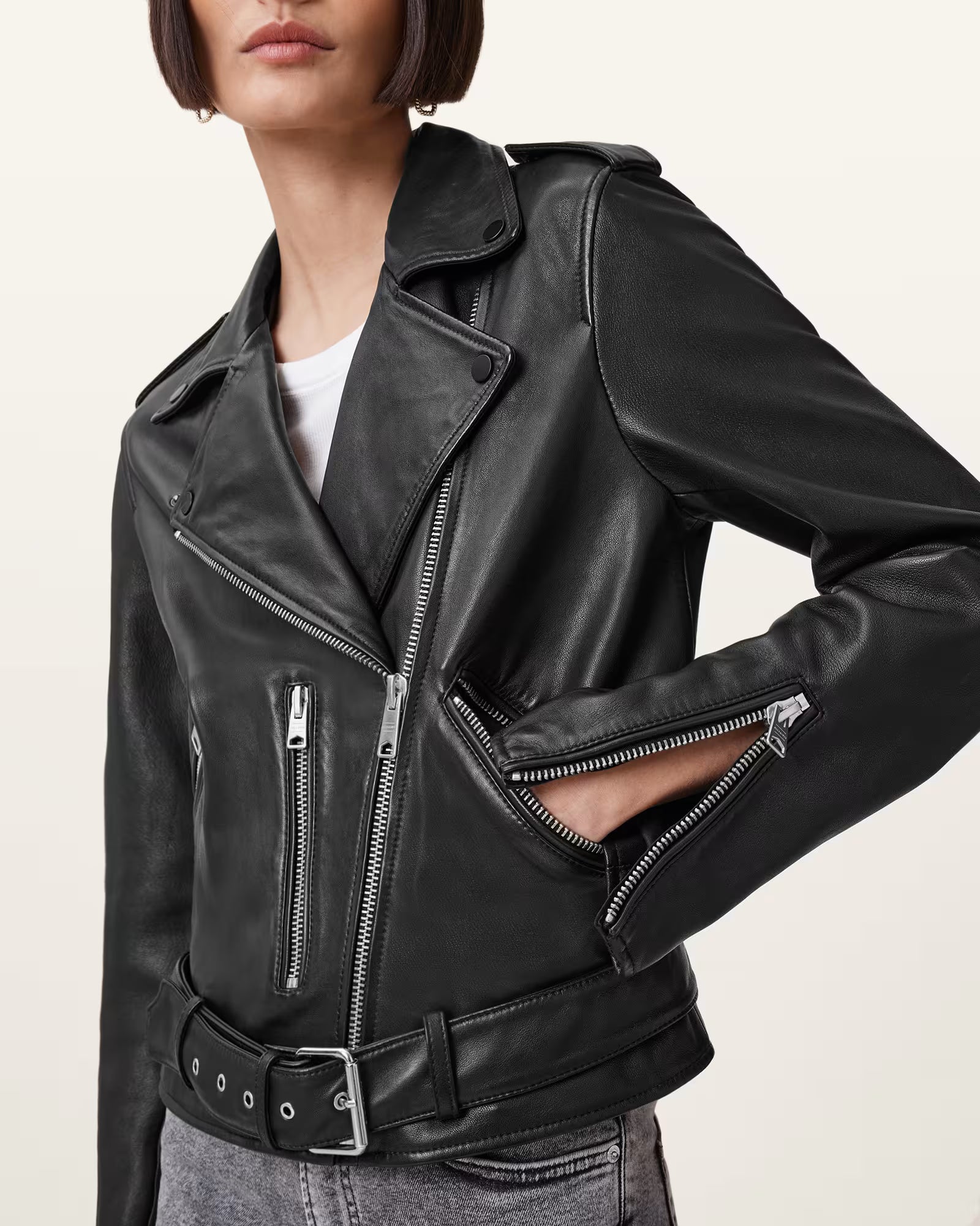 Black leather jacket worn by a person on a plain background