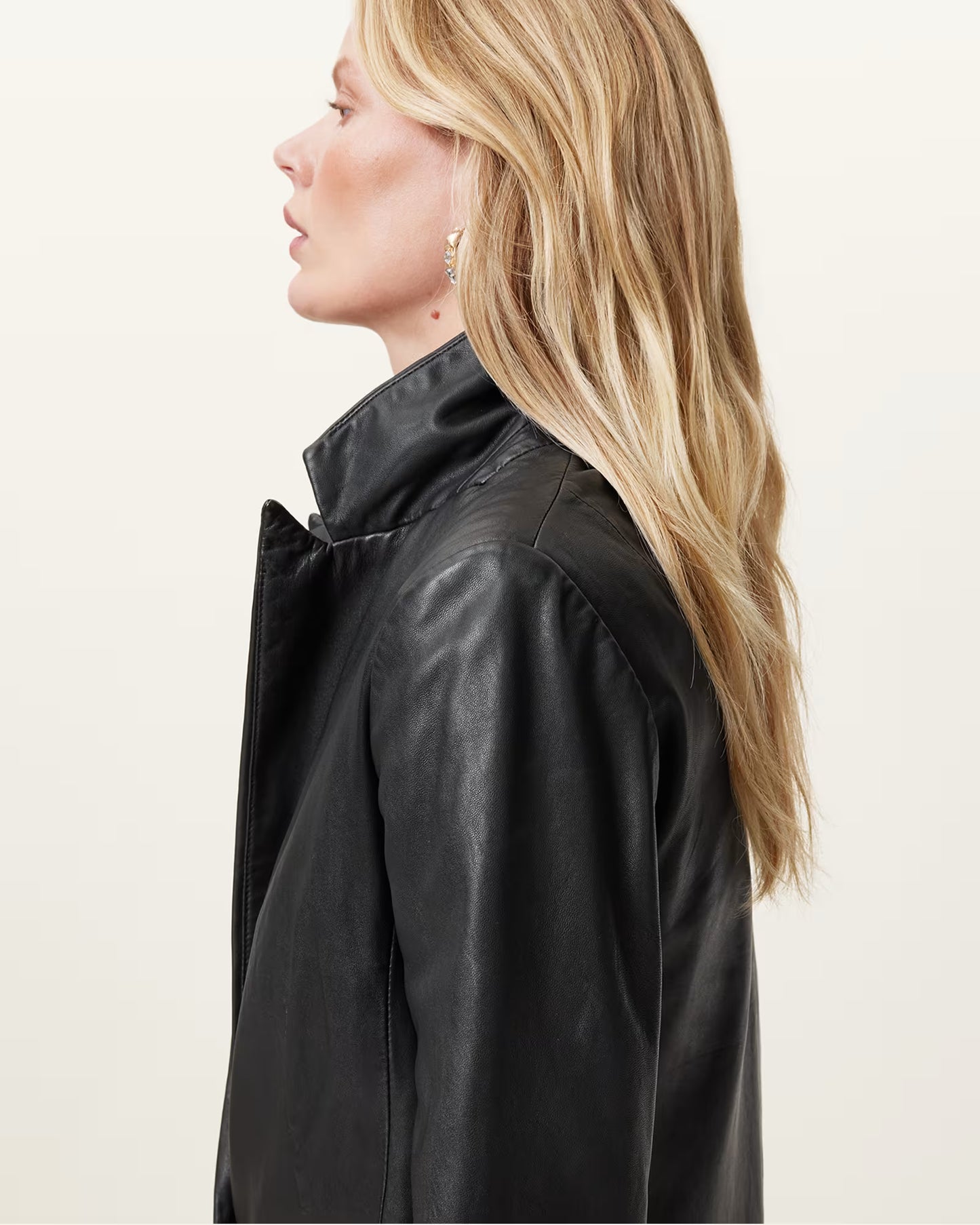 Person wearing a black leather jacket on a plain background