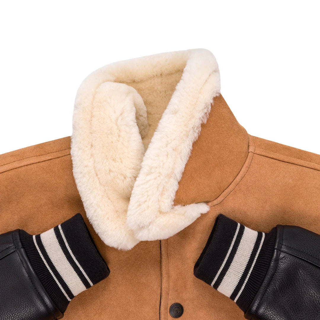 Close-up of a brown jacket with white fur collar and black gloves with white stripes on a white background