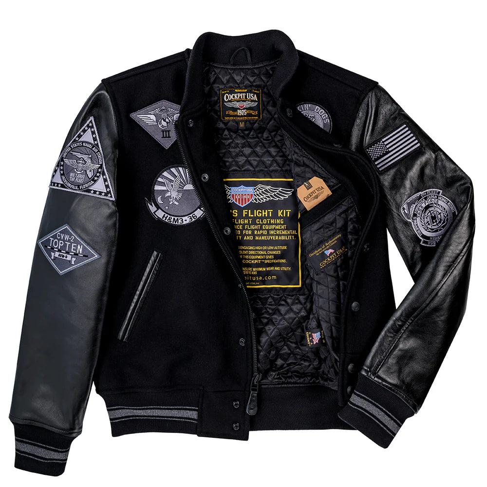 Black leather jacket with various patches and branding on a white background