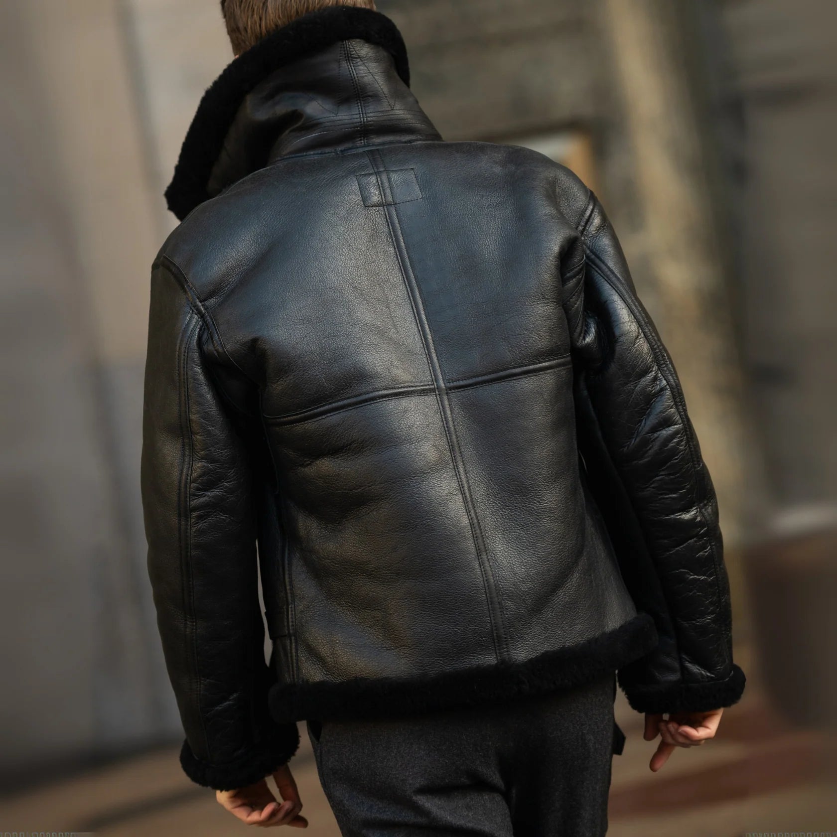 Person wearing a black leather jacket with a blurred background
