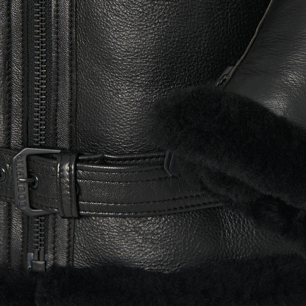Close-up of a black leather jacket with zipper and fur lining.