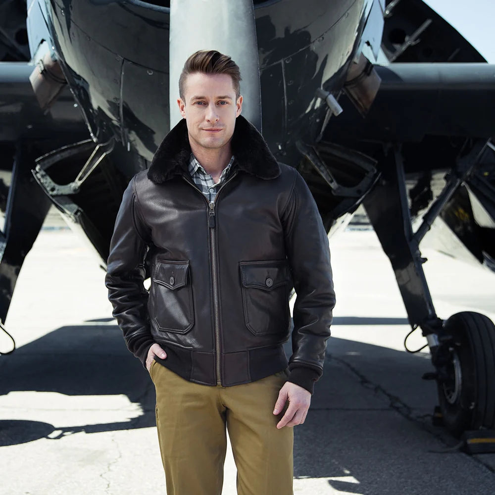 Man wearing a leather jacket standing in front of an airplane